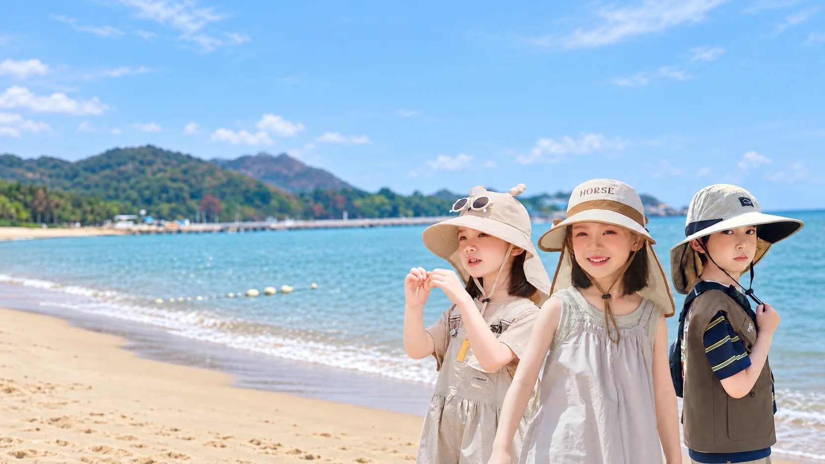 Children wearing summer sun hats by the sea